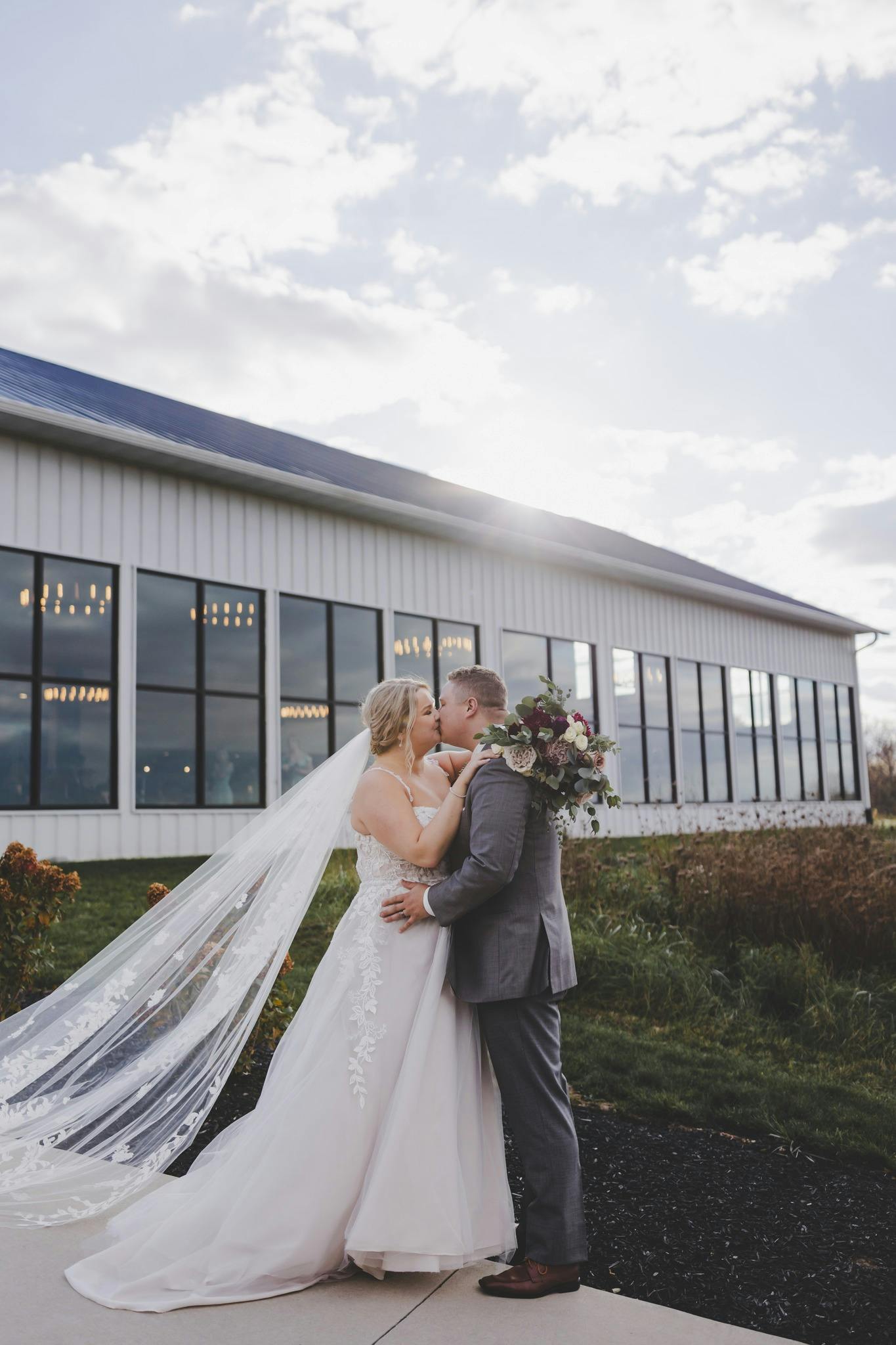 Picture of Bride and groom kissing in front of a building