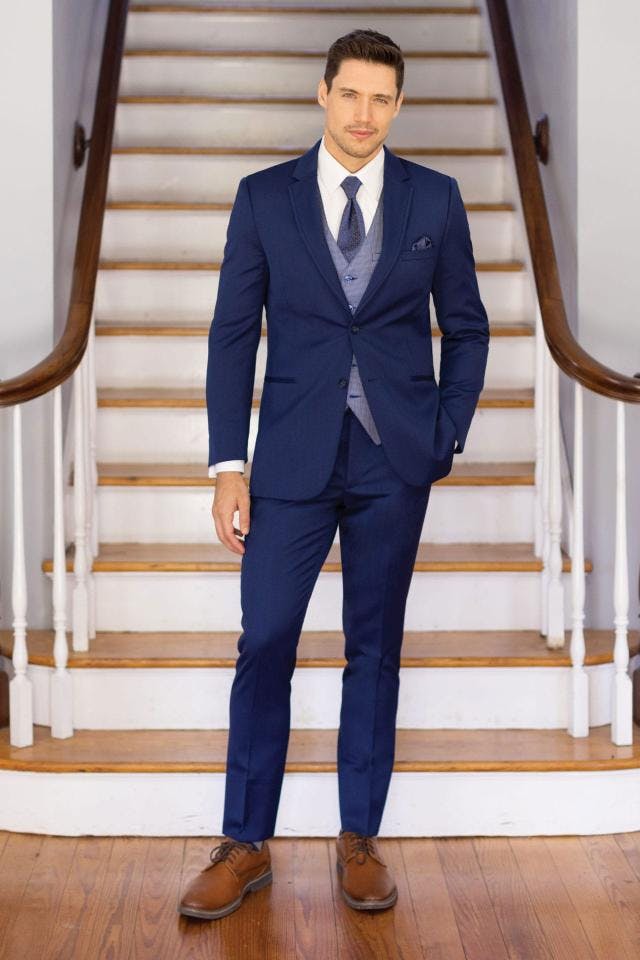 Picture of man in blue tux in front of stairs